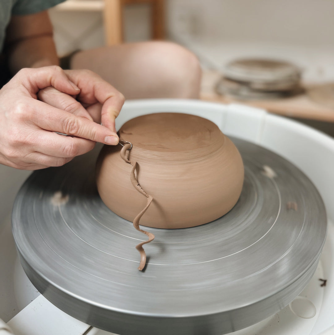 Original Workshops & Classes by Still Life Studio - Potter trimming a piece on the wheel 
