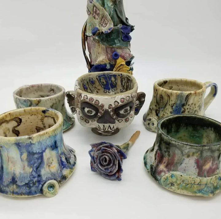 Collection of ceramic cups with artistic designs on a white background