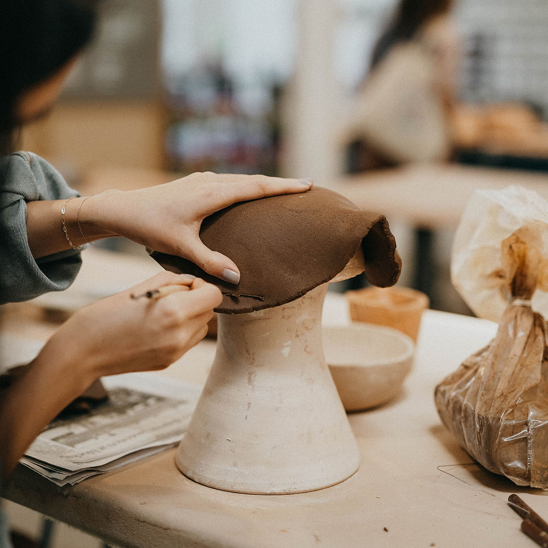 handbuilding a slab of clay over a slump mold 