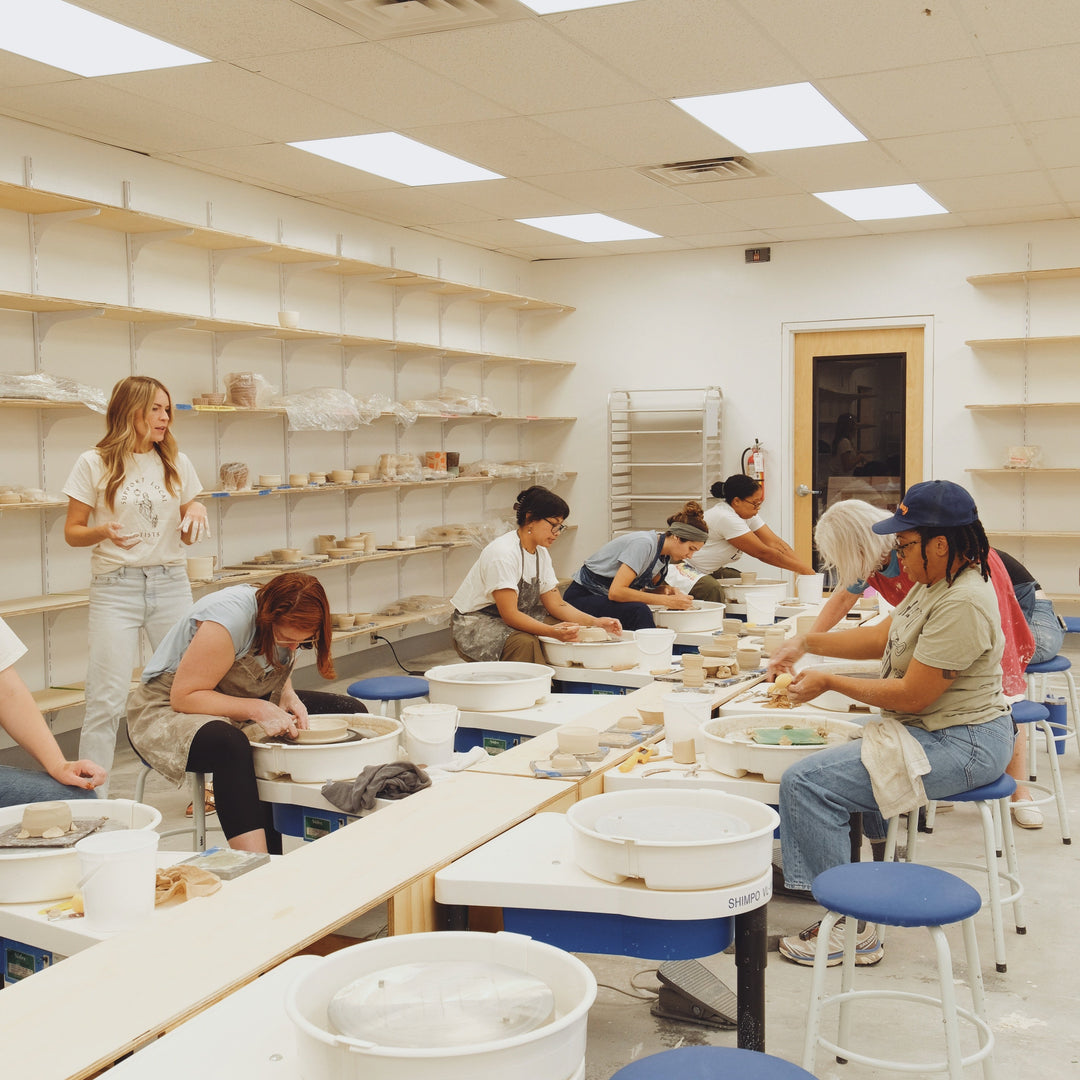People working in a pottery studio. Pottery class handbuilding and wheelthrowing. 